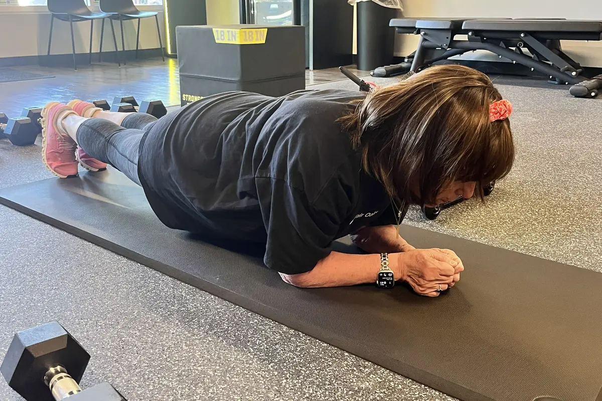Member holding a forearm plank during a session at Alloy Personal Training Fairfax City